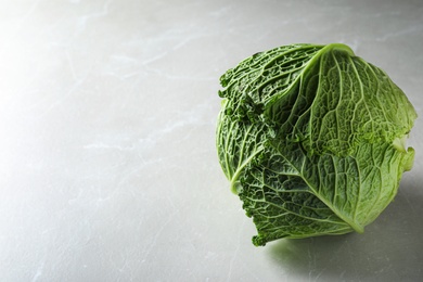 Fresh ripe savoy cabbage on light table, space for text