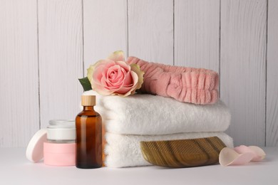 Photo of Composition with different spa products and rose on white table against wooden background