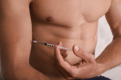 Photo of Athletic man injecting himself, closeup view. Doping concept