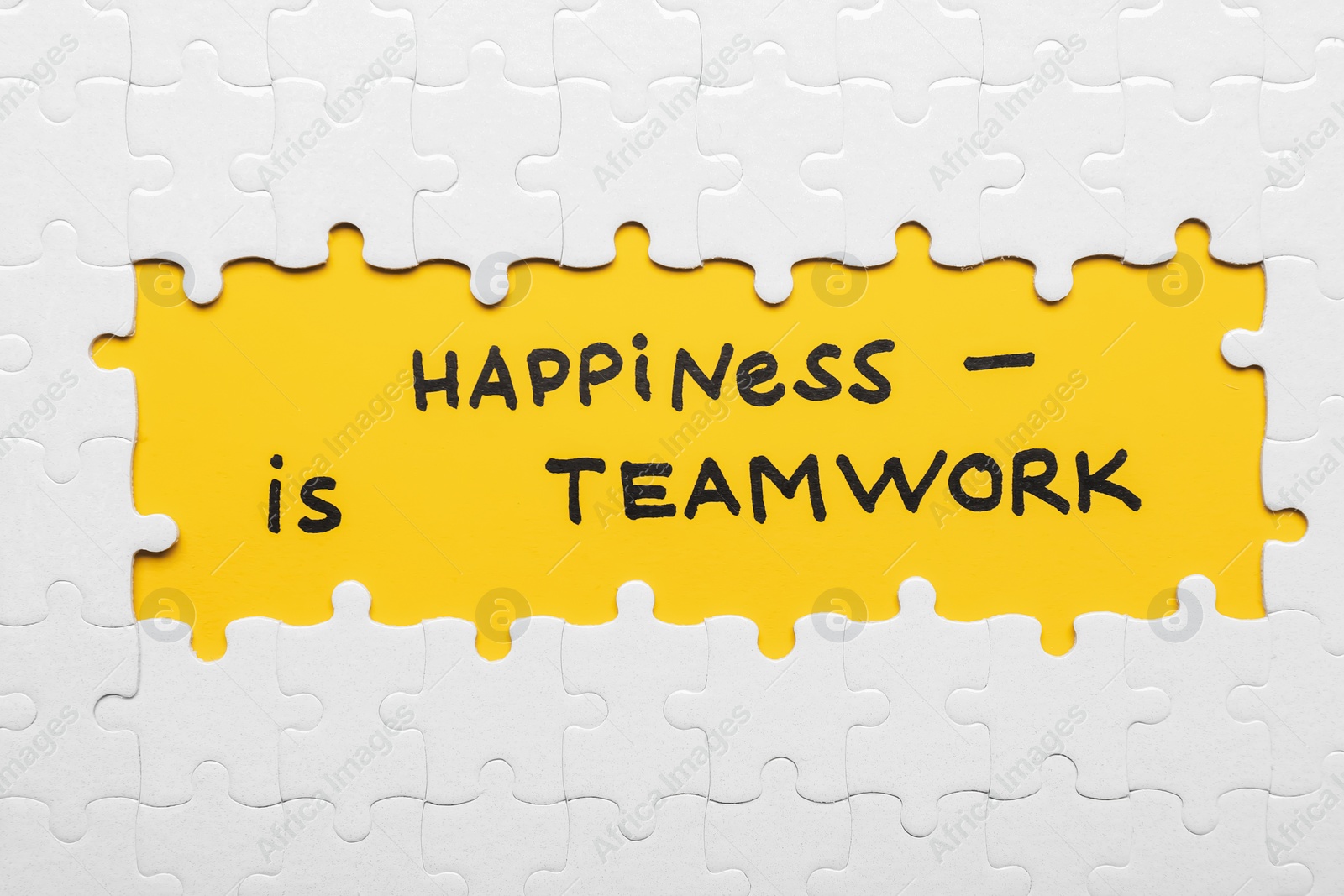 Photo of Recruitment concept. Phrase Happiness Is Teamwork surrounded by assembled white jigsaw puzzle pieces, top view