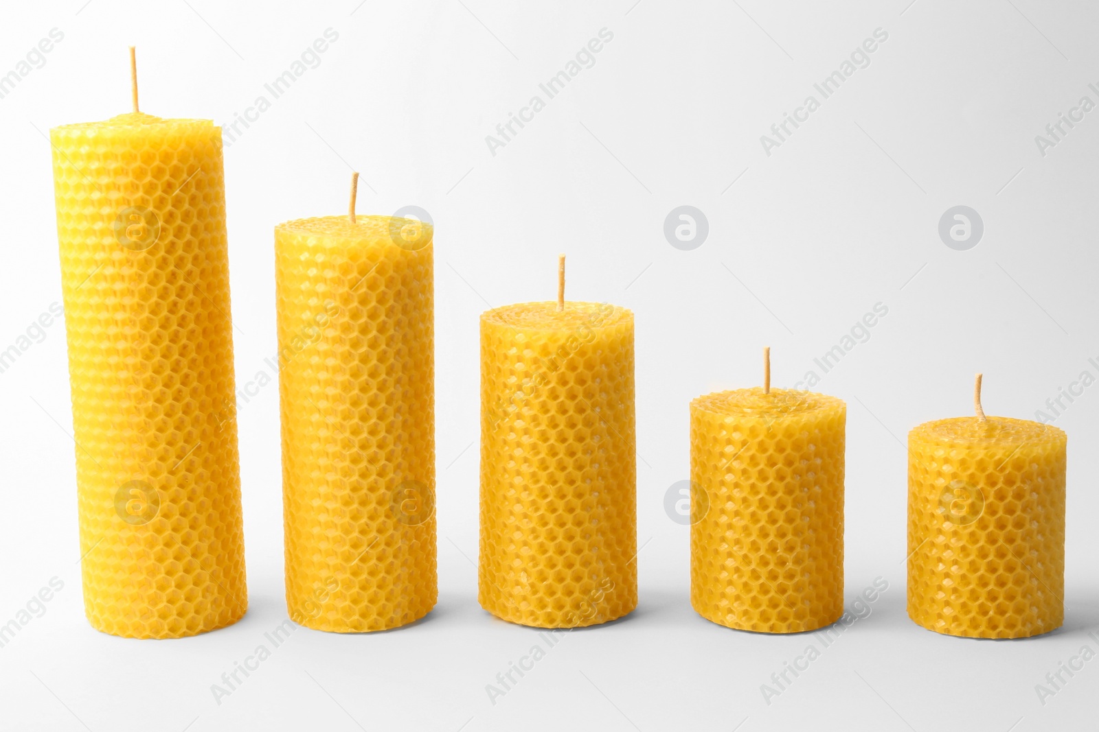 Photo of Stylish elegant beeswax candles on white background