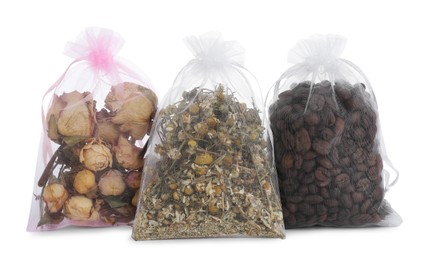 Scented sachets with dried roses, chamomile flowers and coffee beans isolated on white