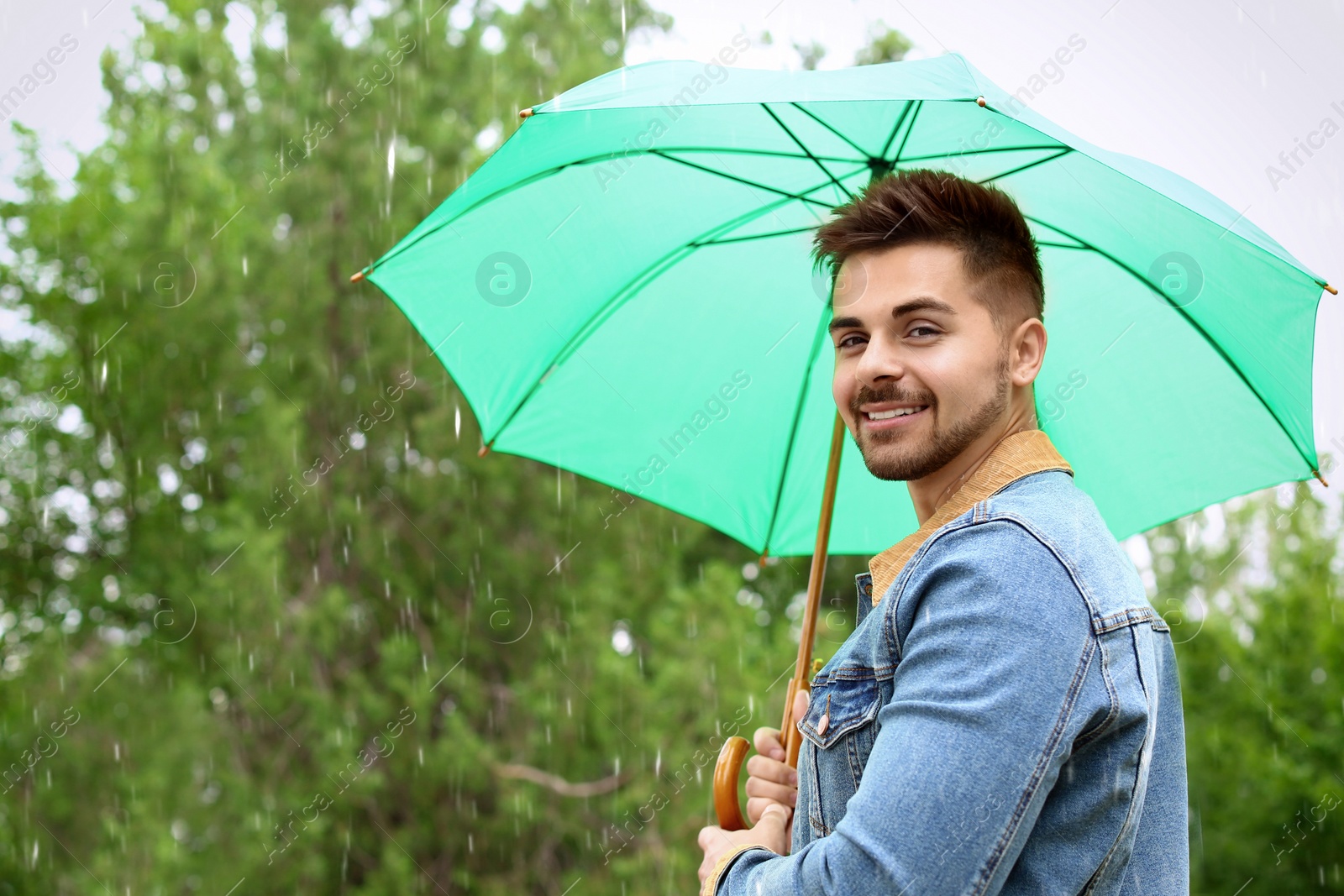 Photo of Man with umbrella outdoors on rainy day