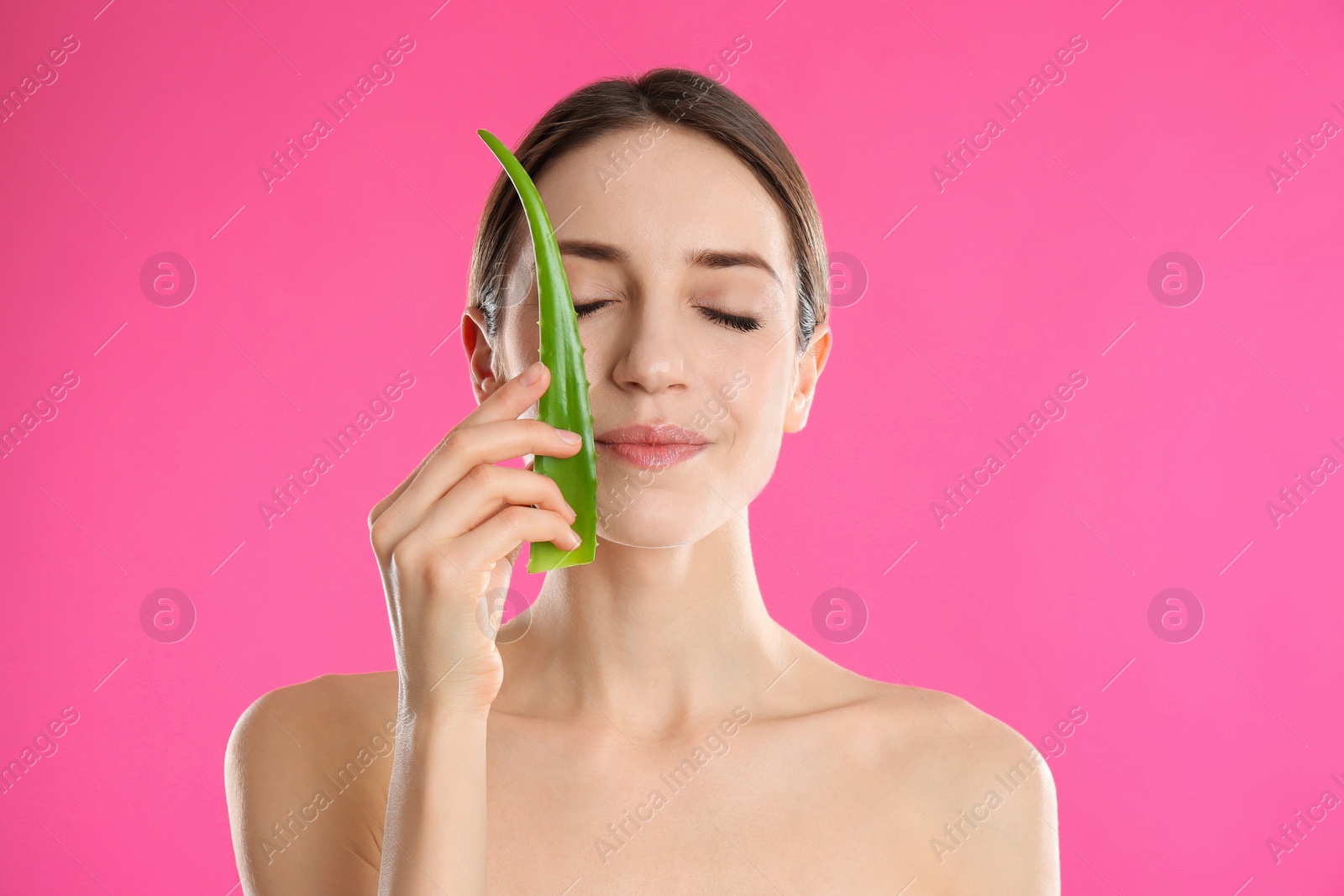 Photo of Young woman with aloe leaf on pink background