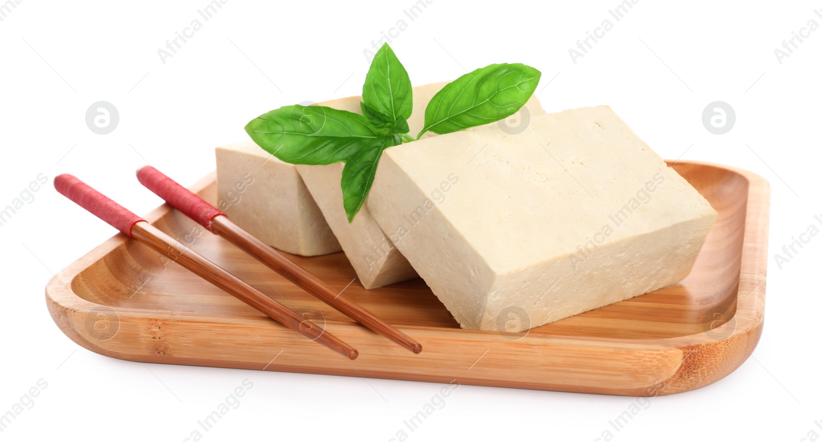 Photo of Wooden plate with delicious raw tofu, basil and chopsticks on white background