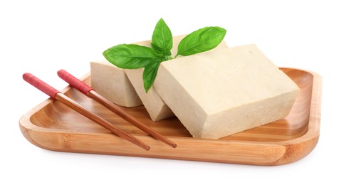 Photo of Wooden plate with delicious raw tofu, basil and chopsticks on white background