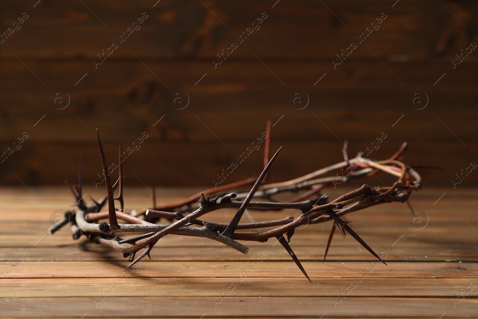 Photo of Crown of thorns on wooden table, space for text. Easter attribute