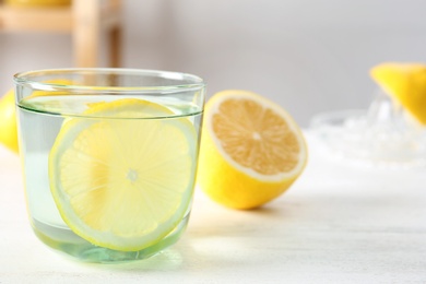 Photo of Glass of water with lemon slice on table