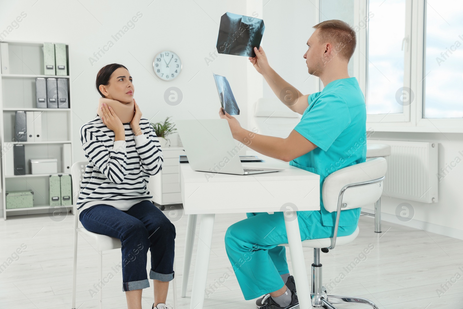 Photo of Doctor with neck MRI images consulting patient in clinic