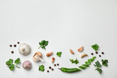 Flat lay composition with green parsley, pepper and garlic on light background