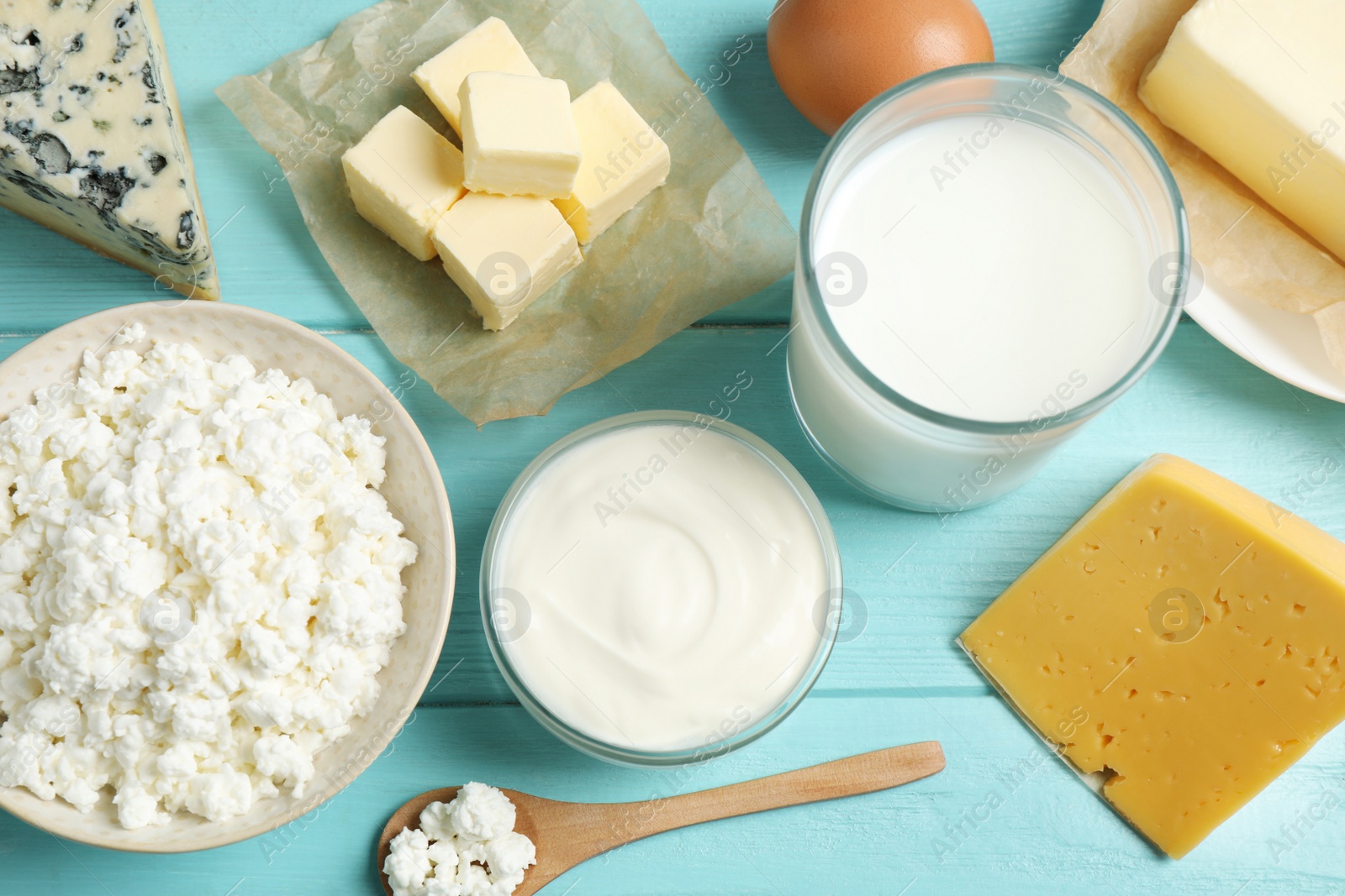 Photo of Different dairy products on blue wooden table, flat lay