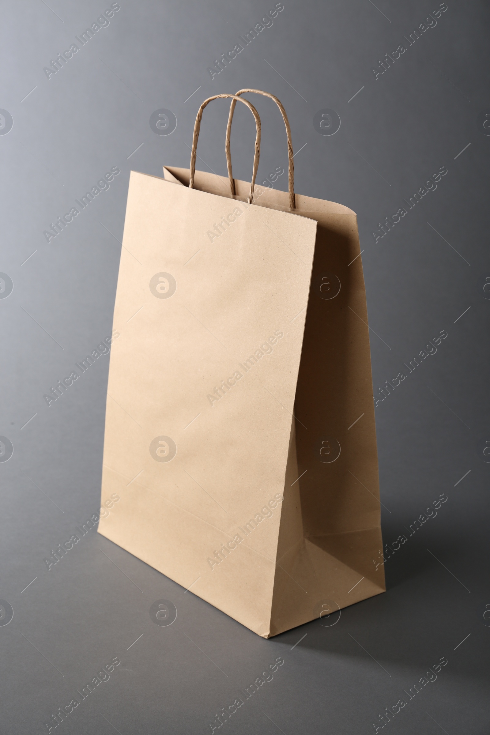 Photo of One kraft paper bag on grey background. Mockup for design