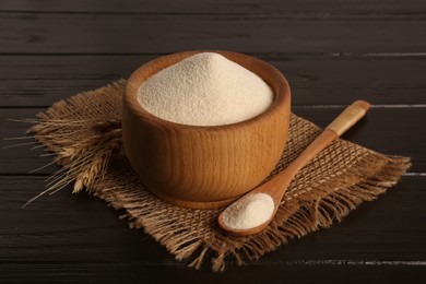 Photo of Fresh semolina and spikelets on black wooden table