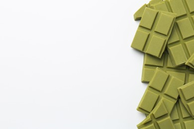 Photo of Pieces of tasty matcha chocolate bars on white background, top view. Space for text