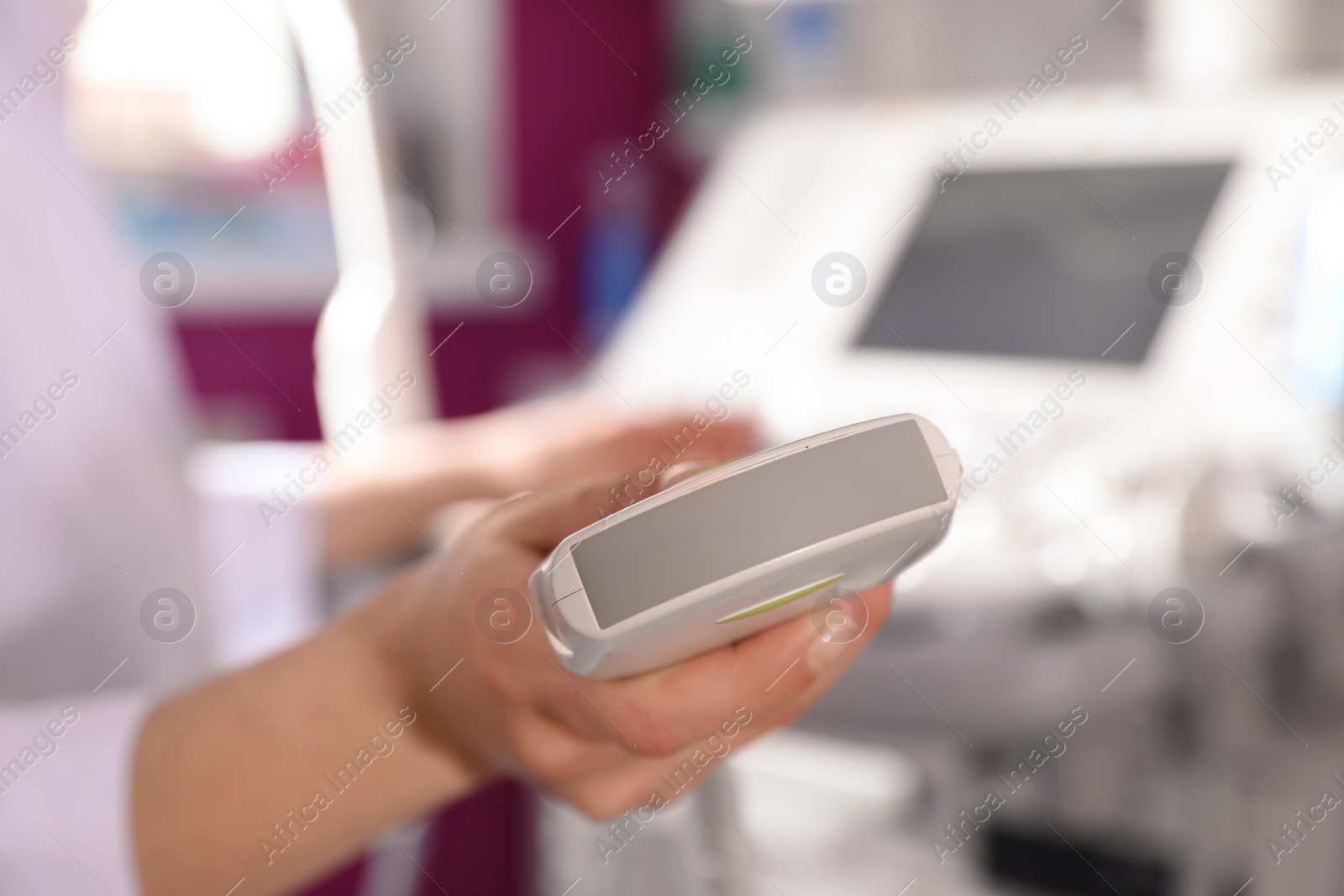 Photo of Sonographer holding ultrasound machine probe in clinic, closeup