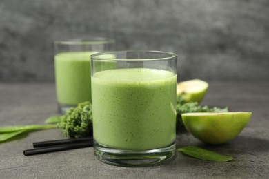 Tasty fresh kale smoothie on grey table, closeup