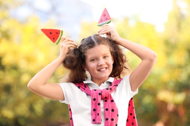 Cute little girl with tasty candies outdoors