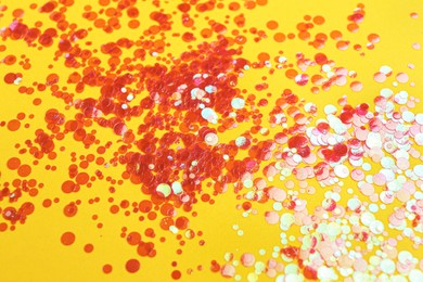 Shiny bright red glitter on yellow background