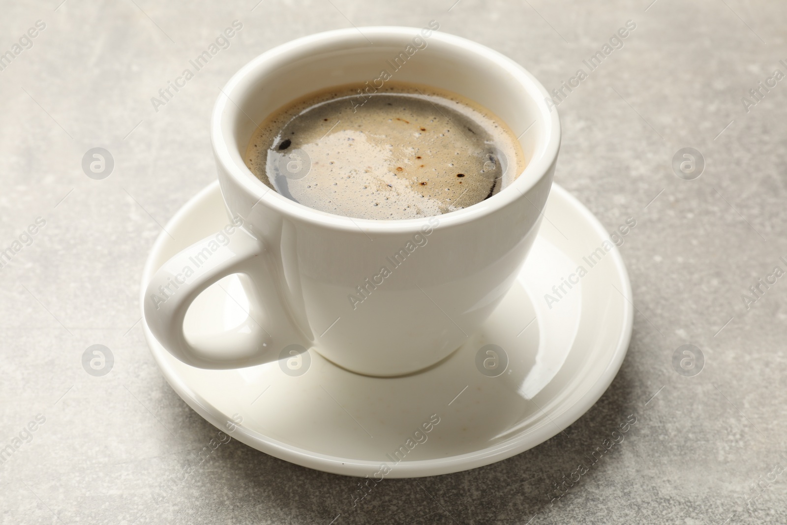 Photo of Cup of aromatic coffee on light grey table, closeup.