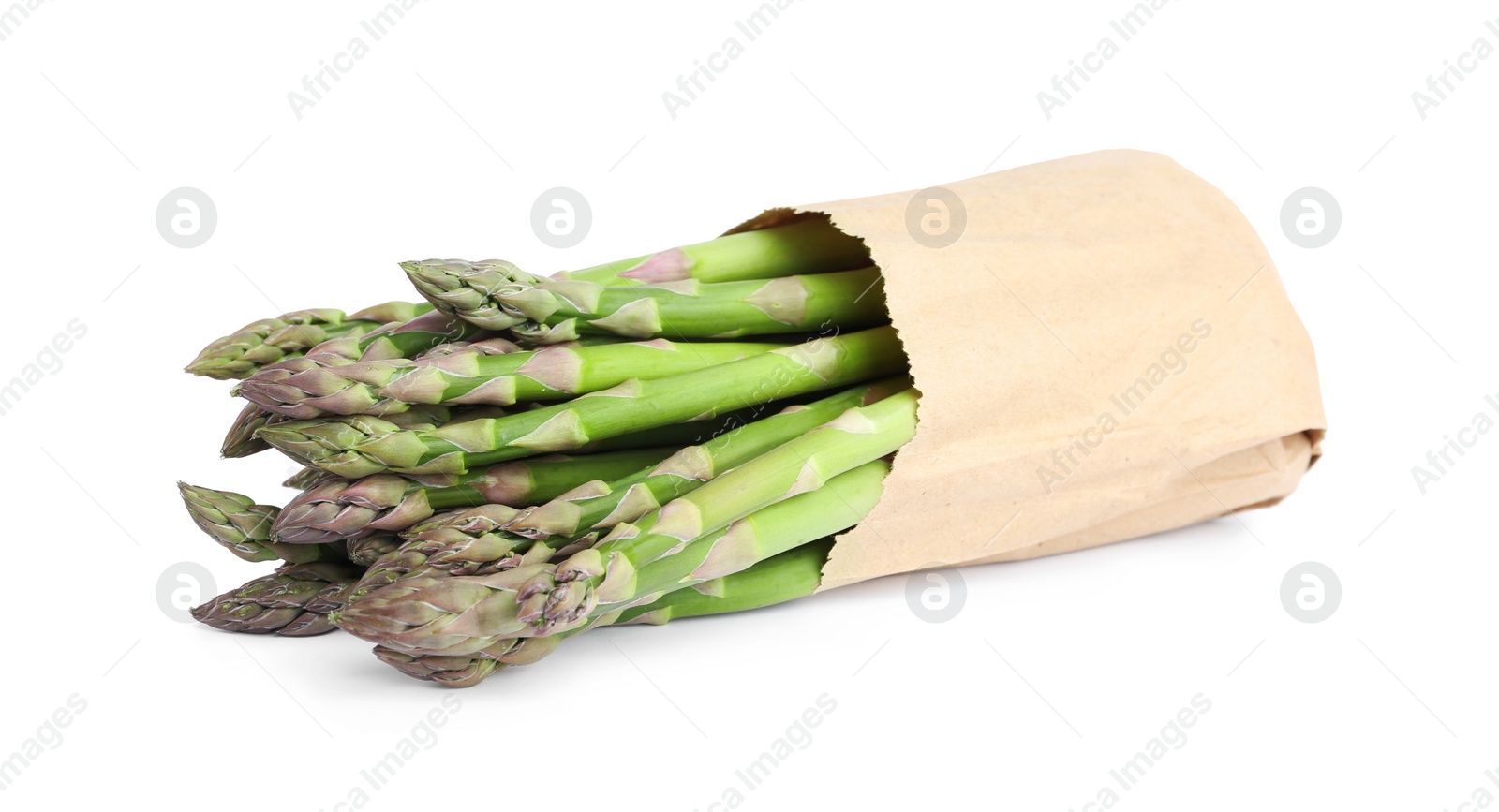 Photo of Fresh raw asparagus in paper bag isolated on white. Healthy eating