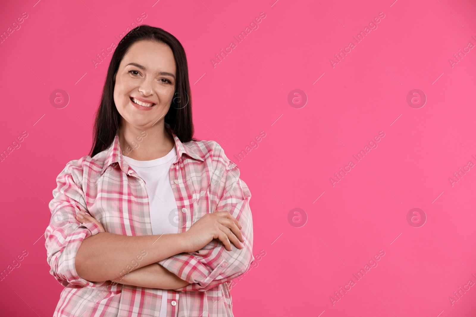 Photo of Beautiful overweight woman with charming smile on pink background. Space for text