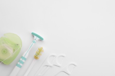 Photo of New tongue cleaner and teeth care products on white background, top view