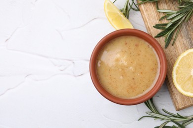 Photo of Delicious turkey gravy, rosemary and lemon on white table, flat lay. Space for text