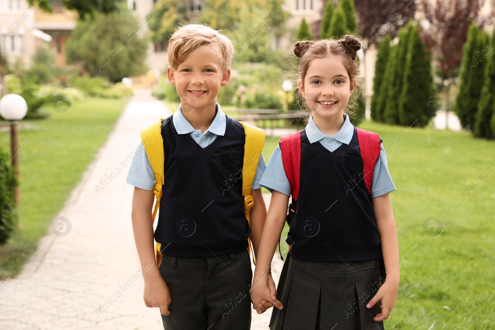 Photo of Little children in stylish school uniform outdoors