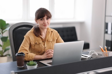 Woman watching webinar at table in office