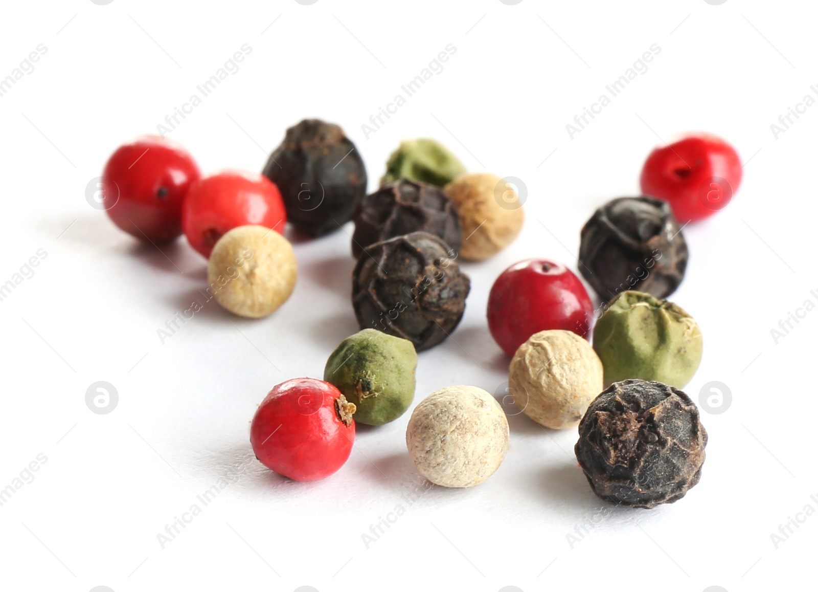 Photo of Scattered aromatic mixed peppercorns isolated on white