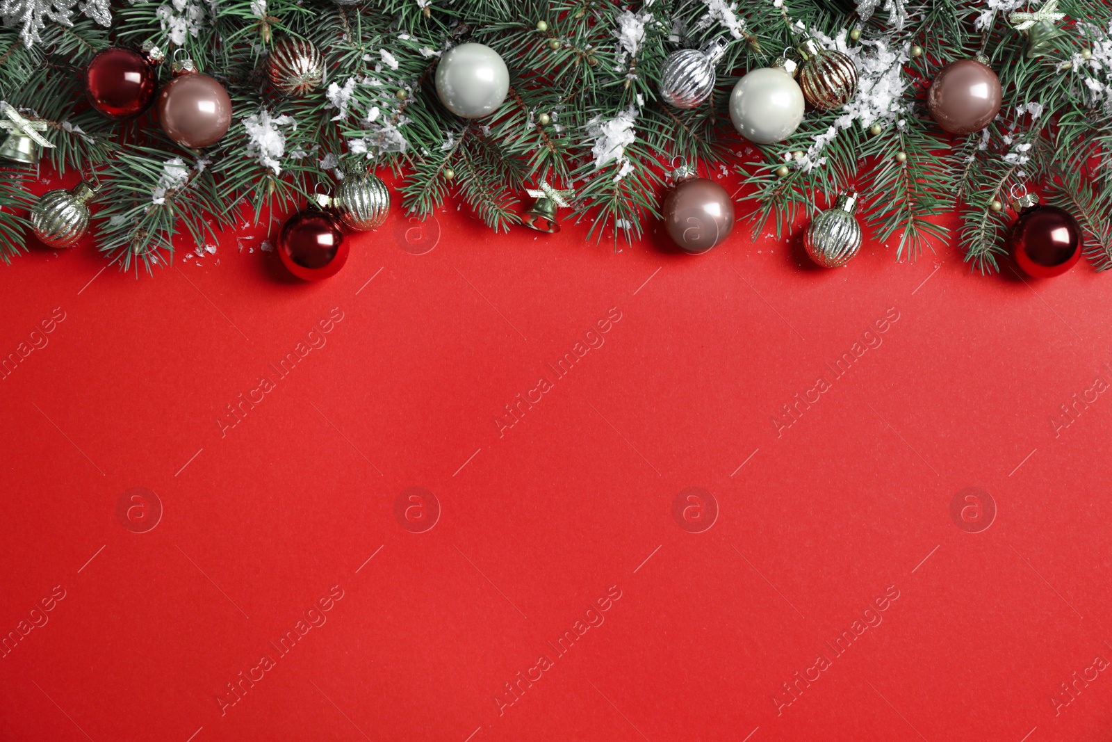 Photo of Fir tree branches with Christmas decoration on red background, flat lay. Space for text