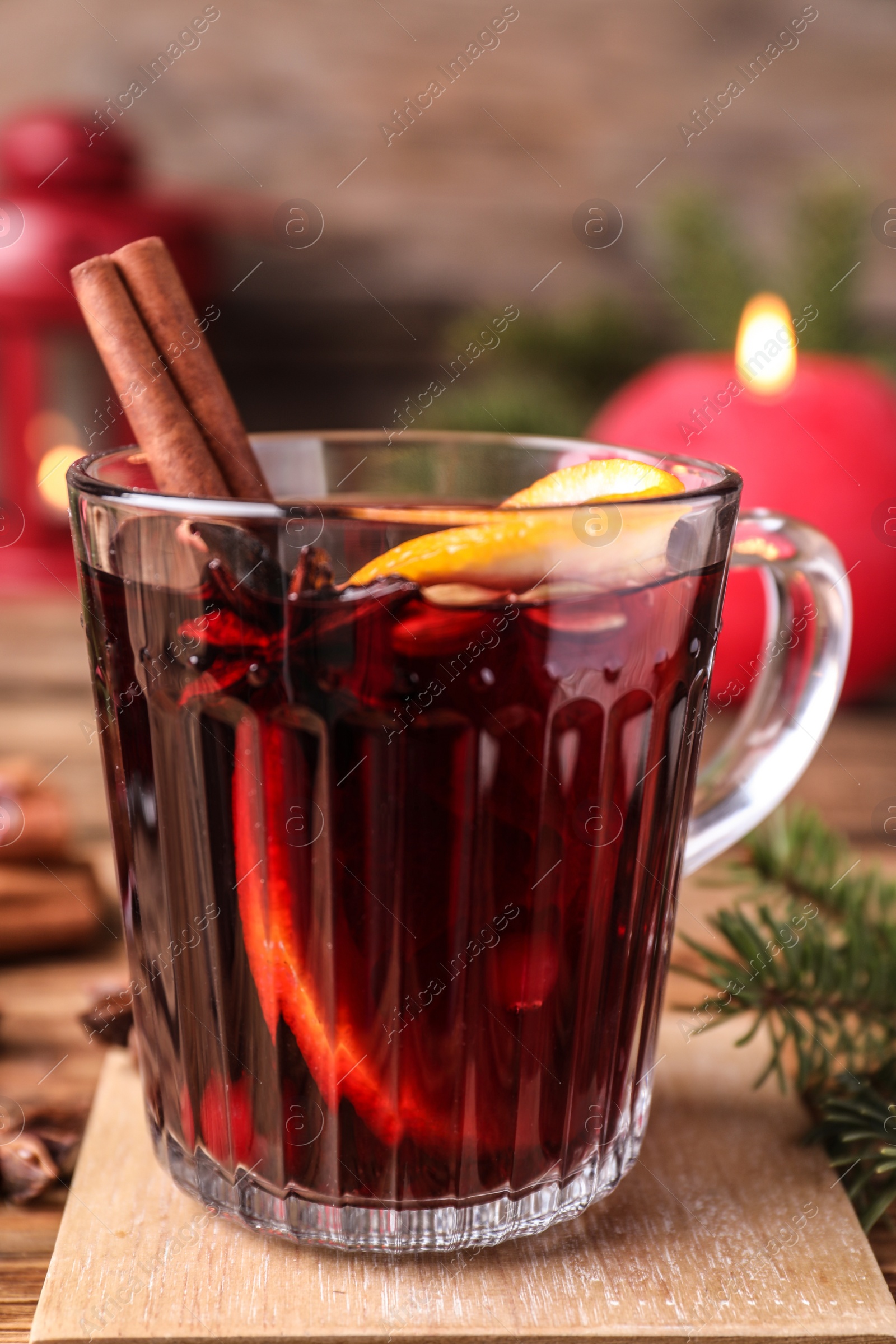 Photo of Aromatic mulled wine on wooden tray, closeup