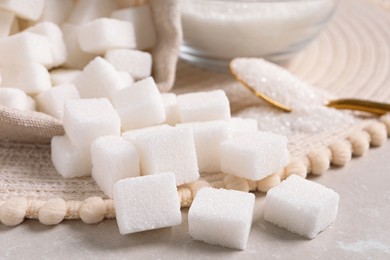Photo of White sugar and wicker mat on light marble table, closeup