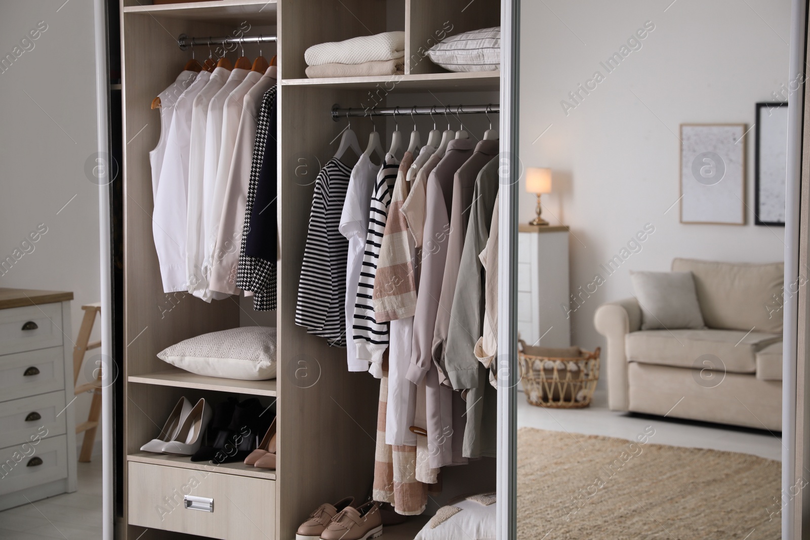 Photo of Wardrobe closet with different stylish clothes, shoes and home stuff in room