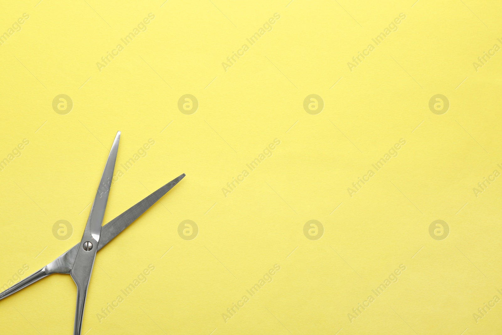 Photo of Pair of sharp scissors on color background, top view. Space for text