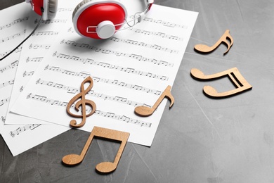 Photo of Music notes and headphones on grey table