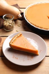 Photo of Plate with piece of fresh delicious homemade pumpkin pie on wooden table