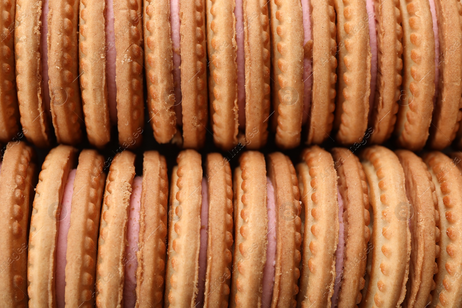 Photo of Tasty sandwich cookies with cream as background, top view