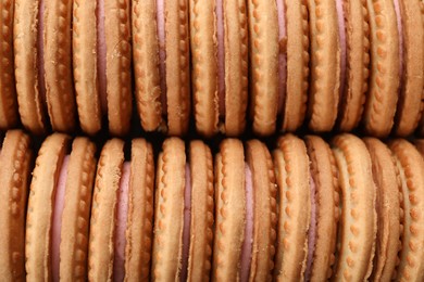 Photo of Tasty sandwich cookies with cream as background, top view