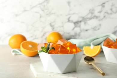 Composition with orange jelly in bowl on  table. Space for text