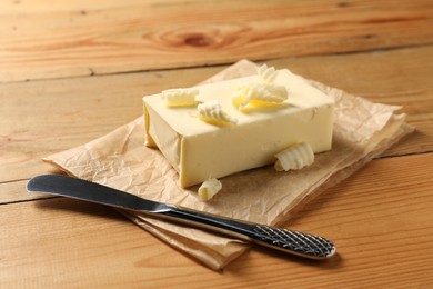 Tasty butter and knife on wooden table