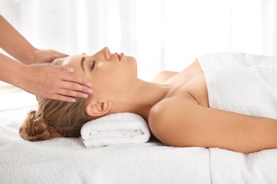 Photo of Relaxed woman receiving head massage in wellness center