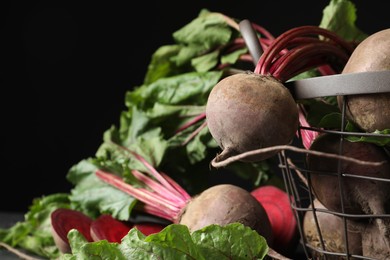 Photo of Whole ripe beets on black background, closeup