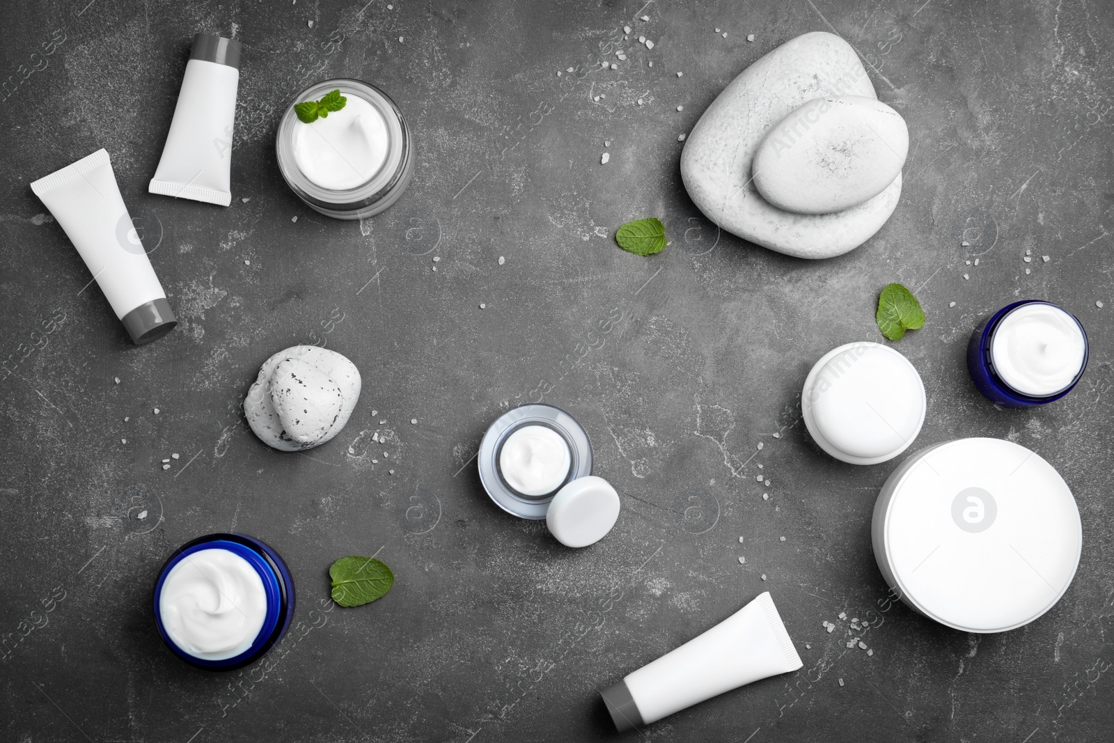 Photo of Composition with body cream in different containers on grey background, top view