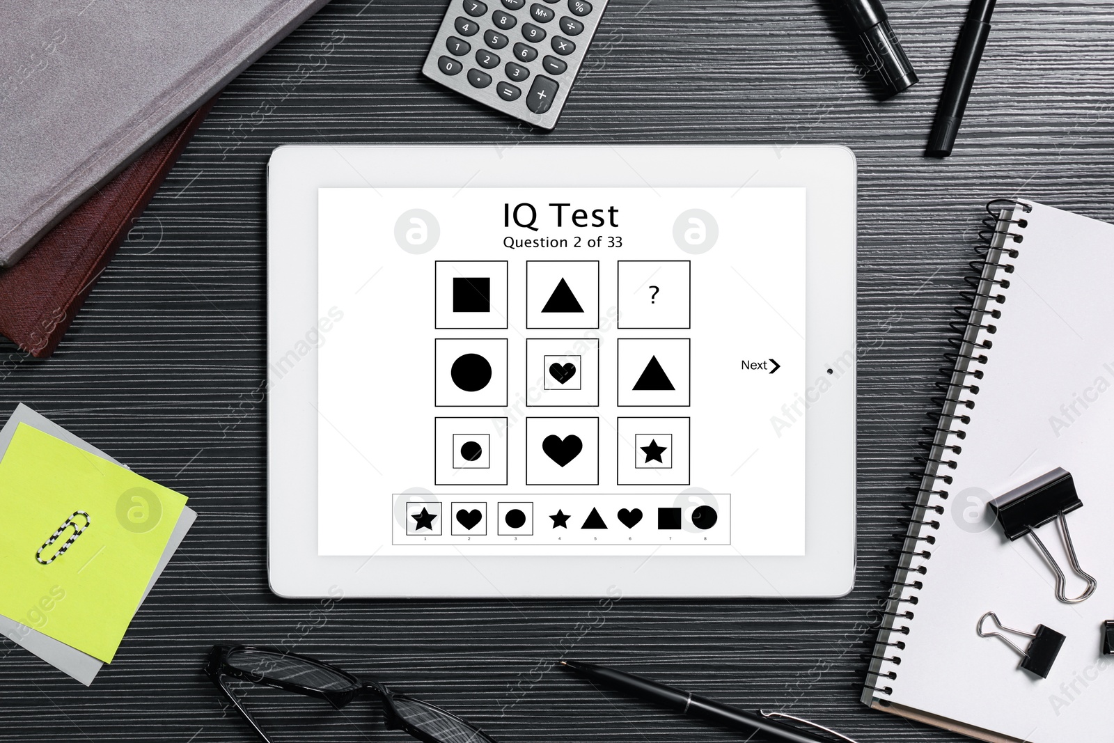 Image of Modern tablet with IQ test on black wooden table, flat lay 