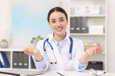 Photo of Medical consultant with stethoscope at table in clinic