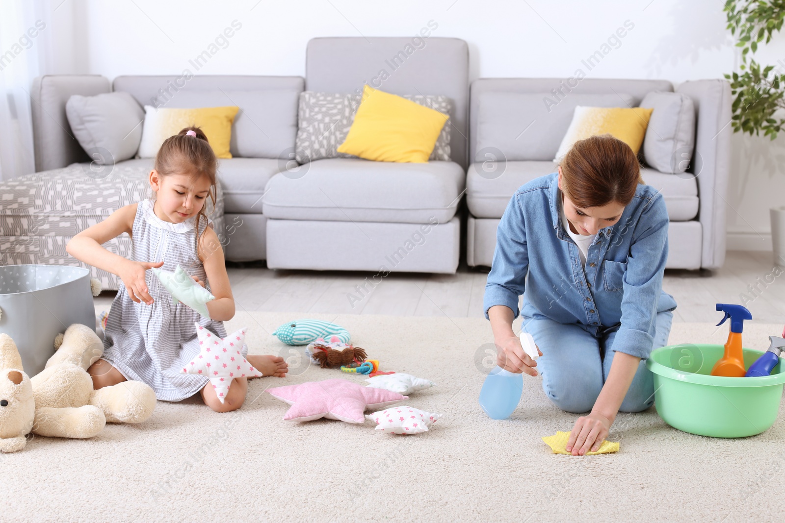 Photo of Housewife and daughter cleaning room together