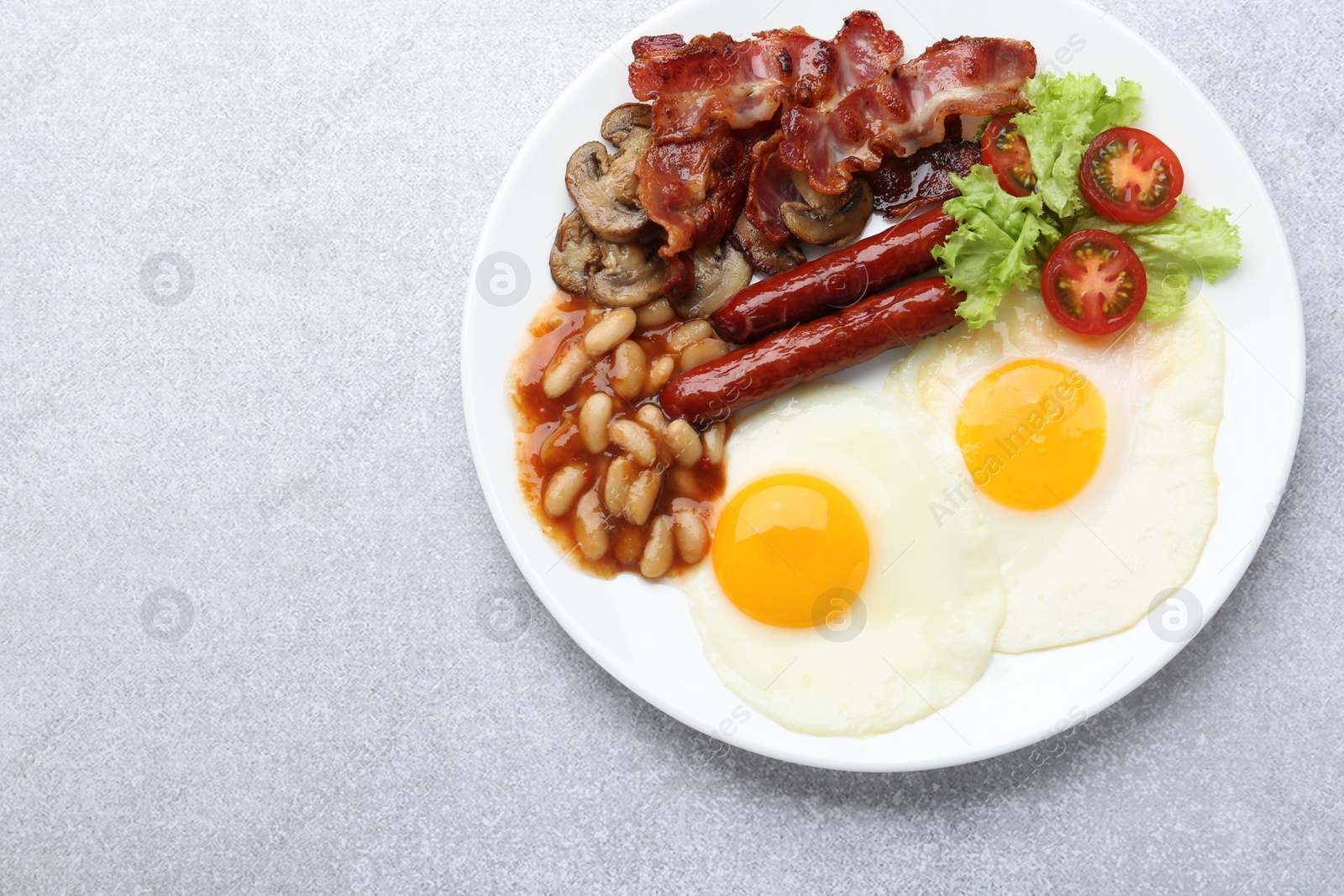 Photo of Delicious breakfast with sunny side up eggs on light table, top view. Space for text