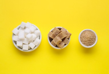 Different types of sugar on yellow background, flat lay