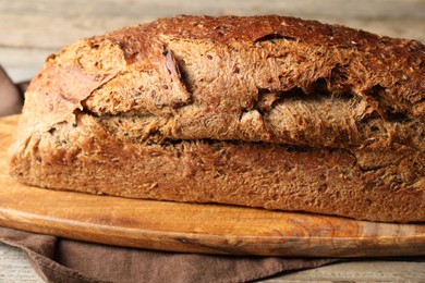 Photo of Freshly baked sourdough bread on wooden table, closeup